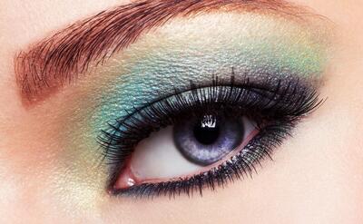 Woman's eye with green eye make-up.