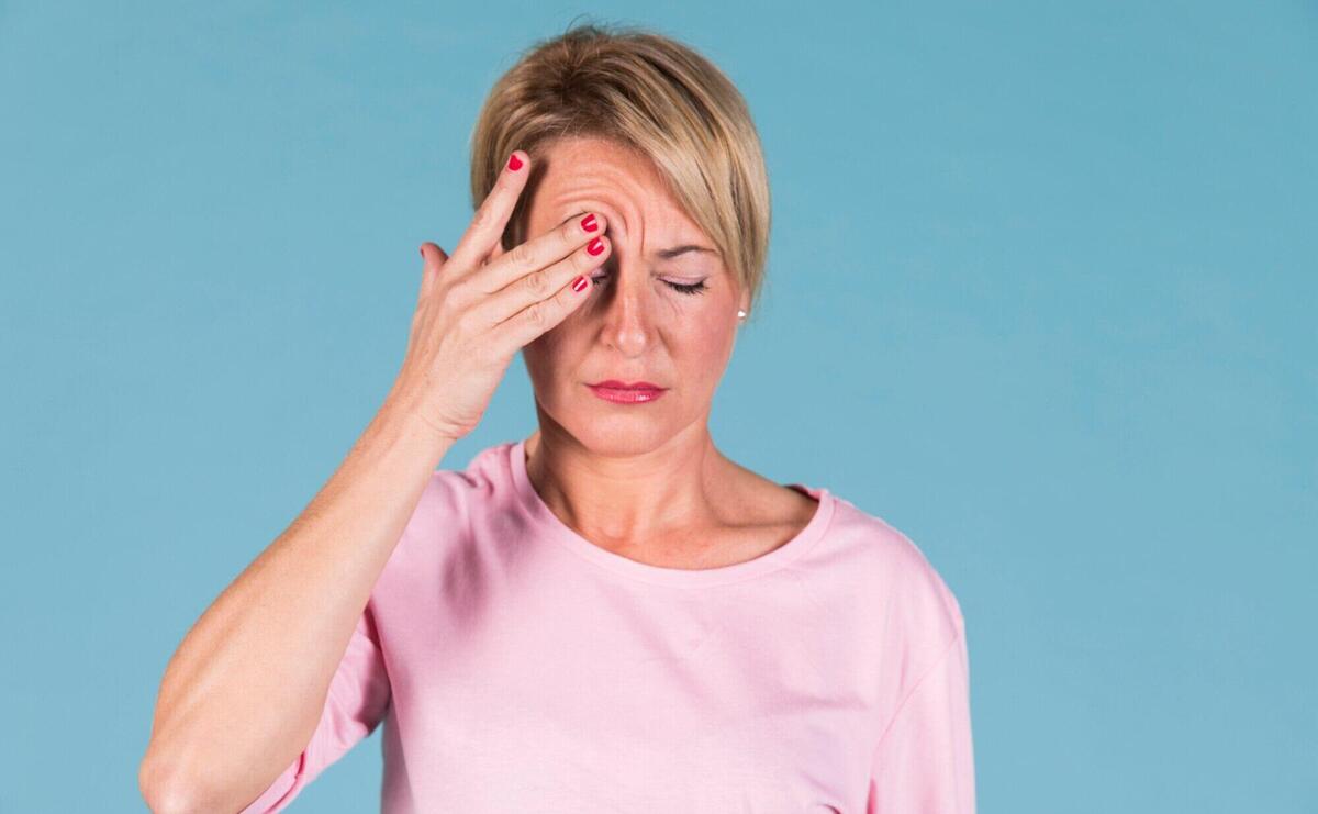 Portrait of a woman holding his head in pain