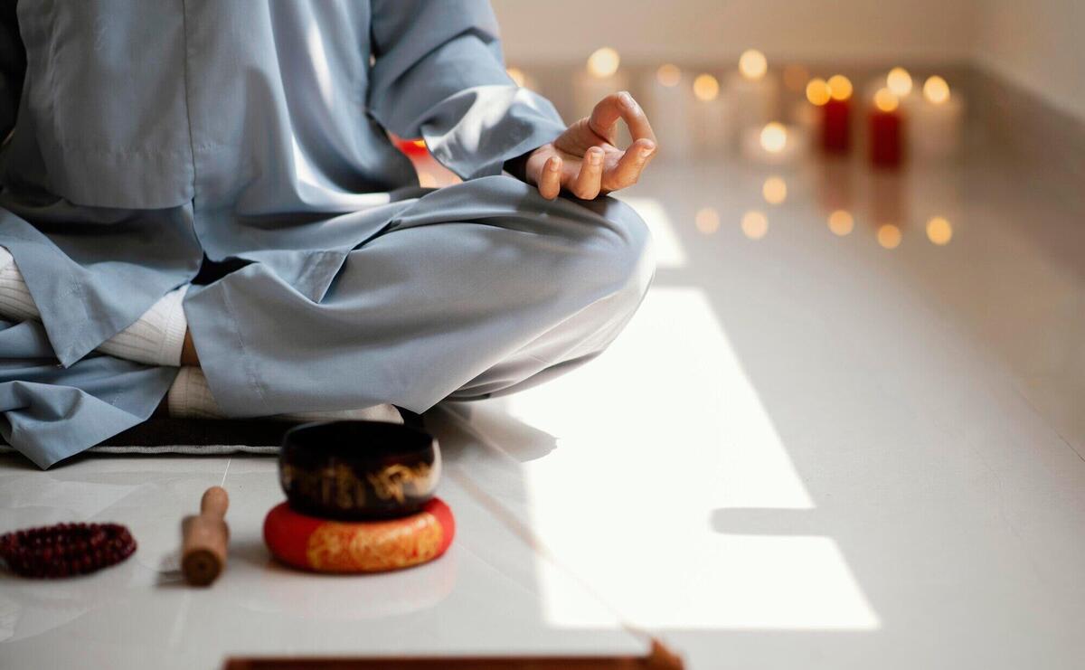 Front view of woman meditating with incense and candles