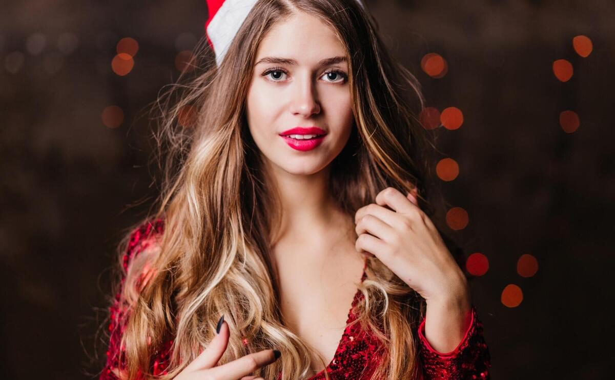 Gorgeous beautiful woman with light-brown hair looking to camera with intetest during new year