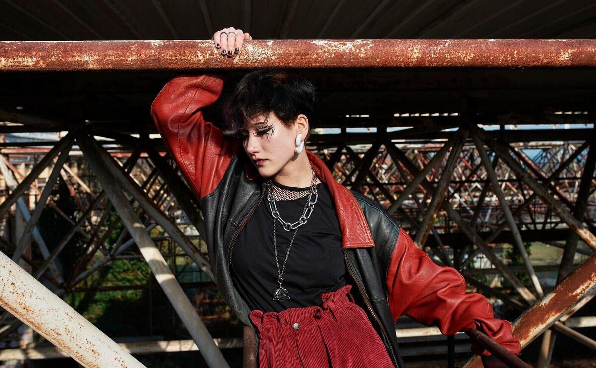 Pop punk aesthetic portrait of woman posing on metal structure