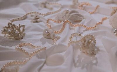 Sophisticated pearl necklaces elegantly draped on coral, signifying luxury and nature's beauty.