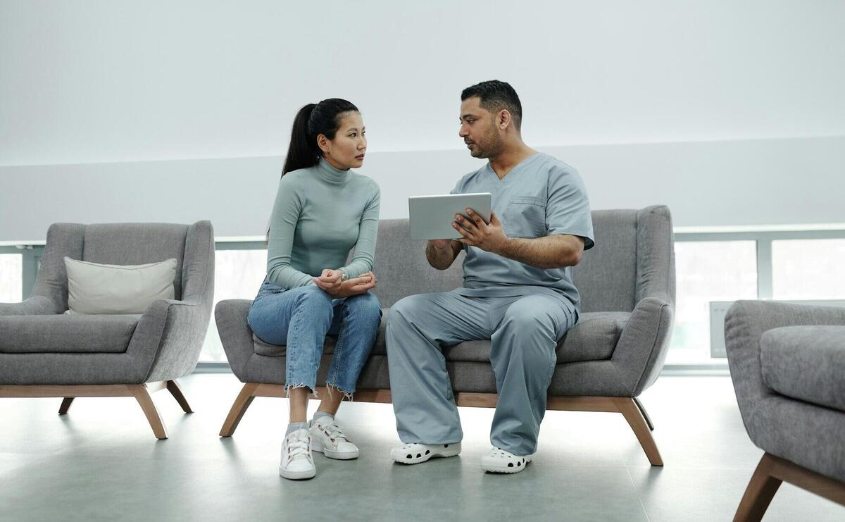 Healthcare provider consulting a patient with a tablet, emphasizing technology in healthcare.