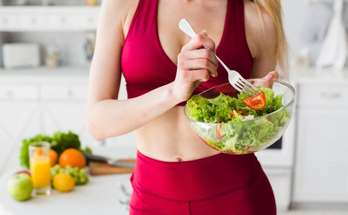 Diet concept with sporty woman in kitchen