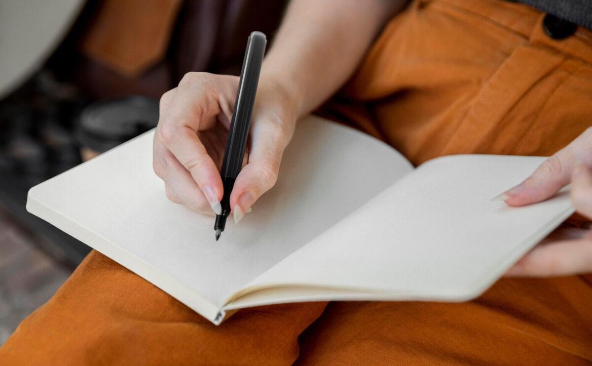 Close-up woman writing in journal