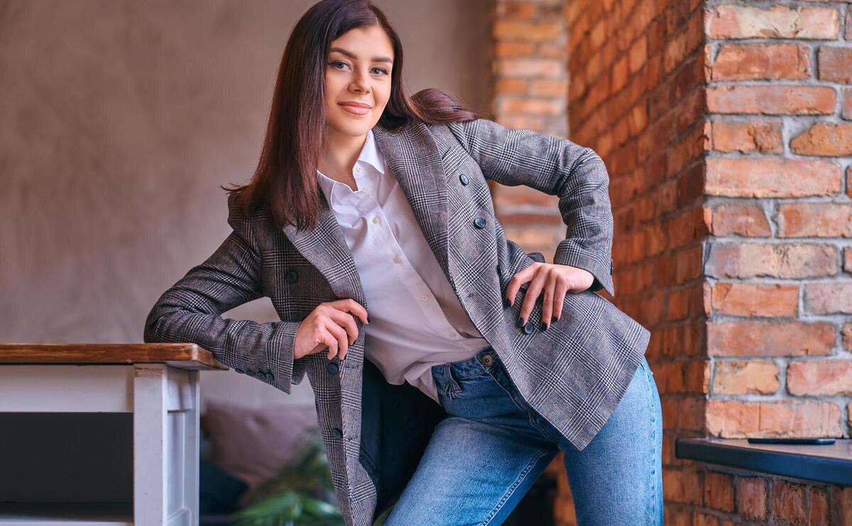 Portrait of a sexy brunette leaning on a table in a room with lo