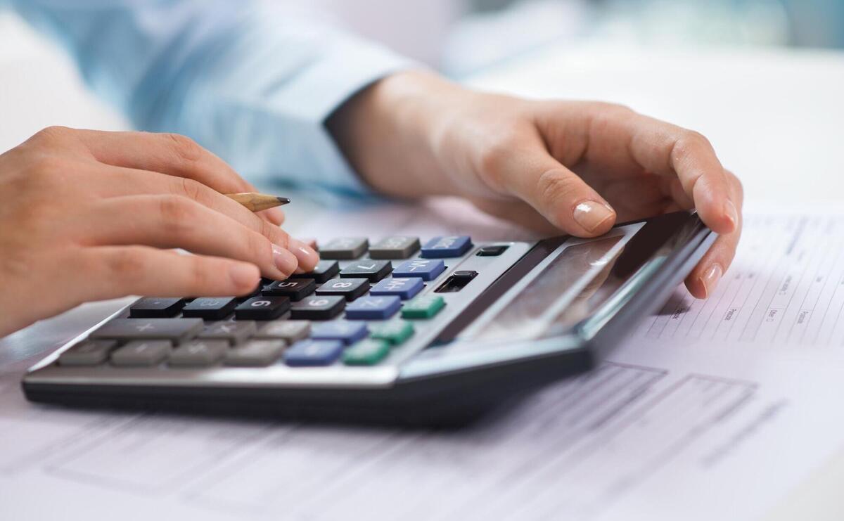 Closeup of economist working and counting data on calculator