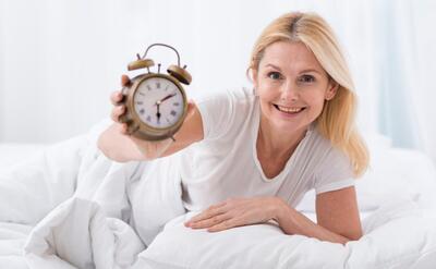 Beautiful senior woman holding a clock