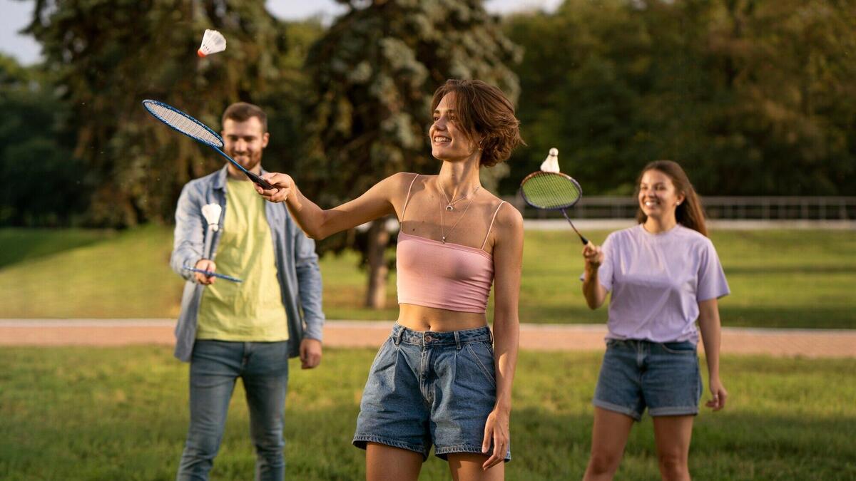 Front view smiley friends playing badminton