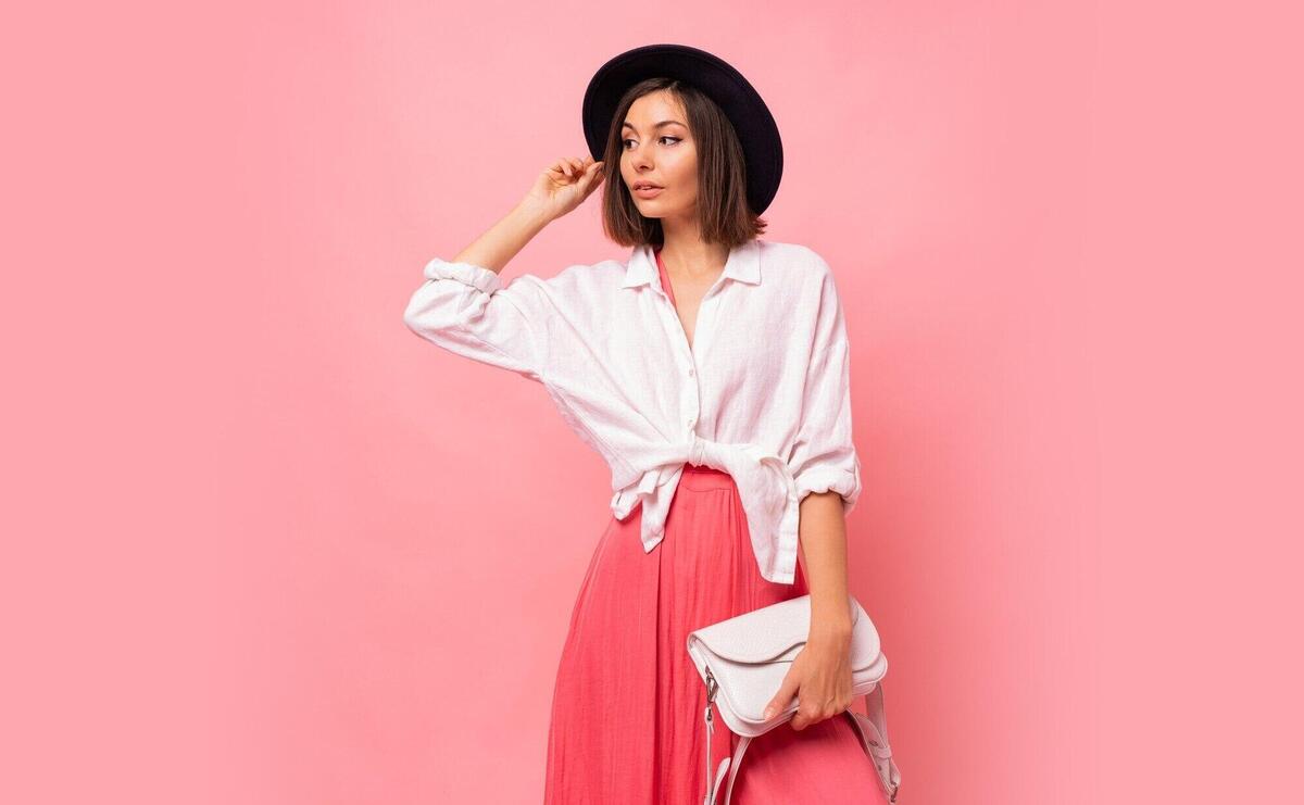 Fashion  photo of  graceful  brunette woman in  spring outfit posing   Holding white bag.