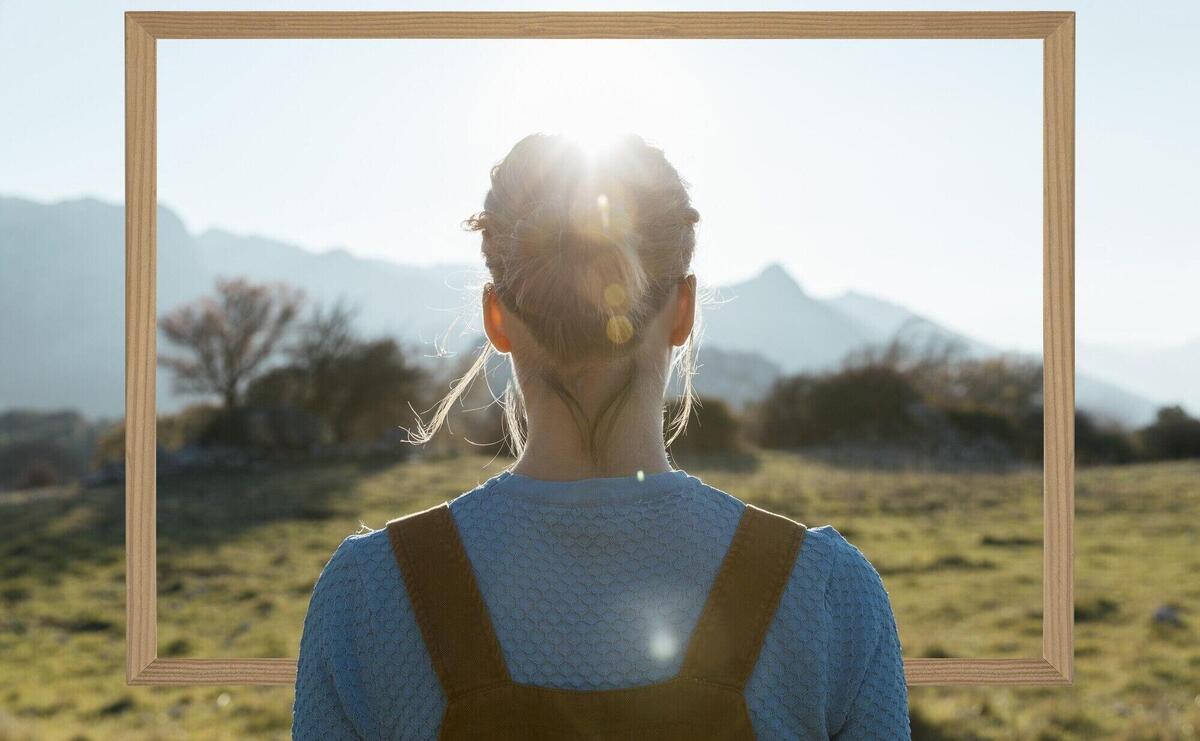 Person holding frame with open nature landscape concept