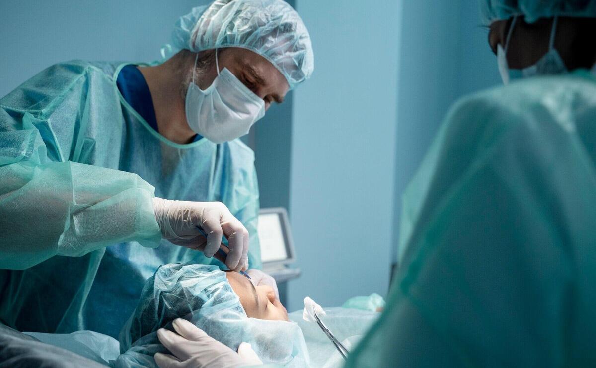 Doctors performing rhinoplasty in operating room