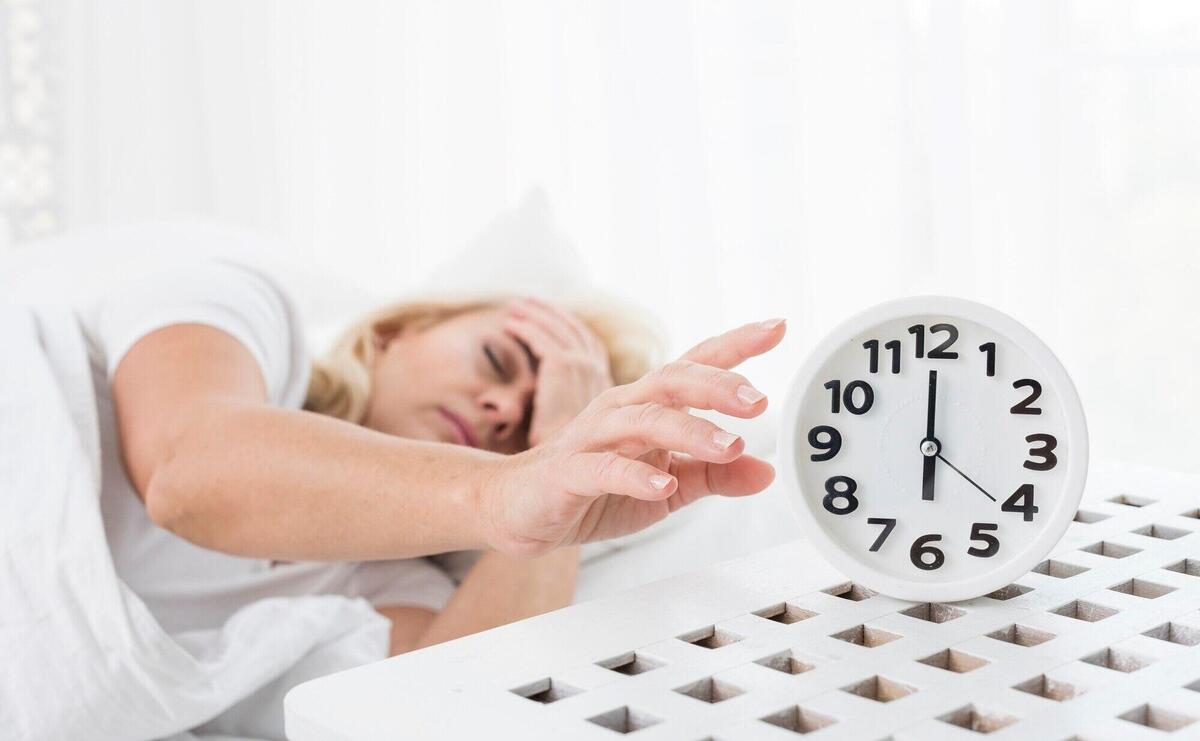 Medium shot woman sleeping with clock