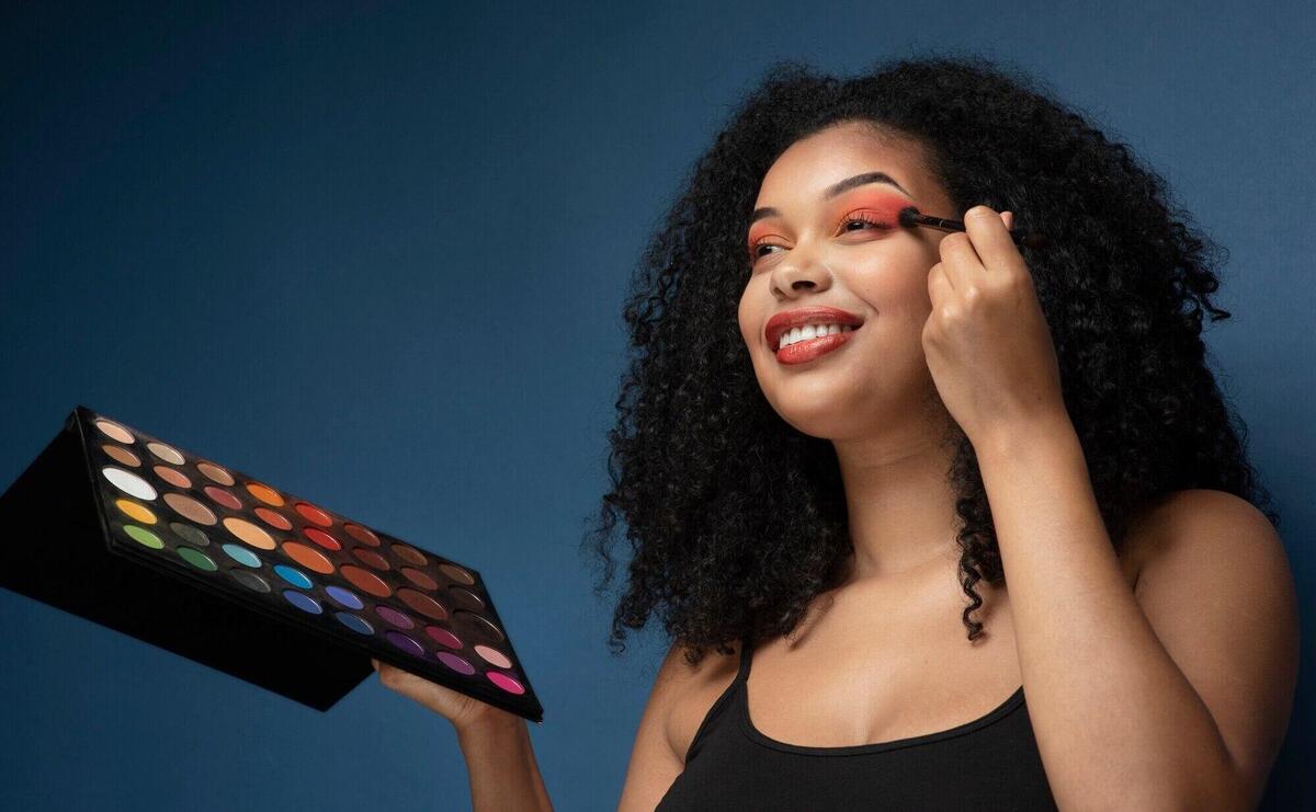 Portrait of a gorgeous woman applying eyeshadow with a make-up brush