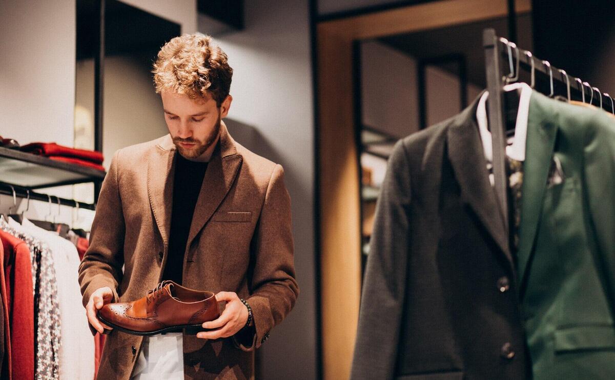 Young handsome man choosing shoes at a shop