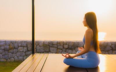 Portrait young asian woman do meditation around sea beach ocean at sunrise