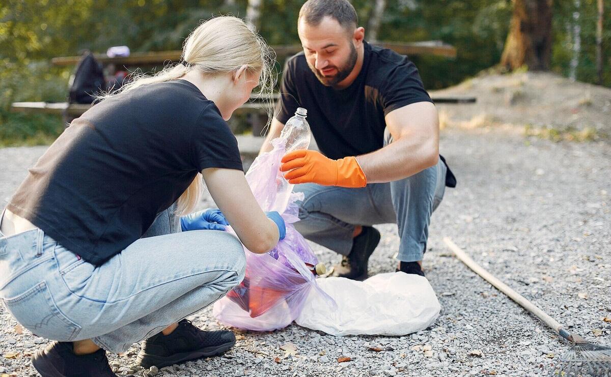 Couple collects garbage in garbage bags in park