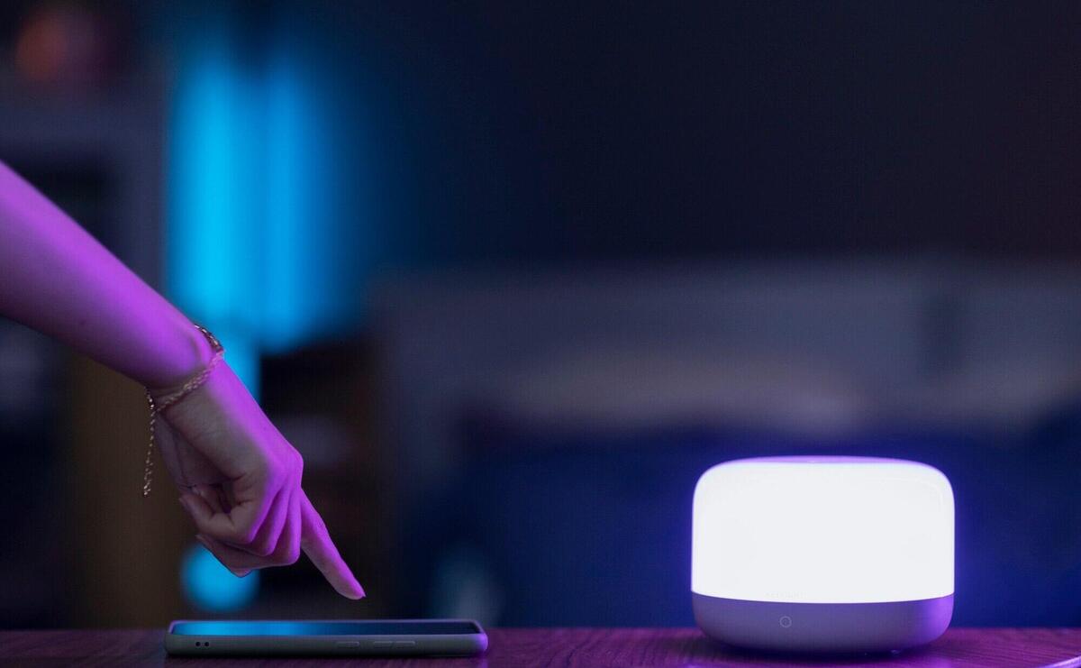 Side view hand with smartphone and smart light