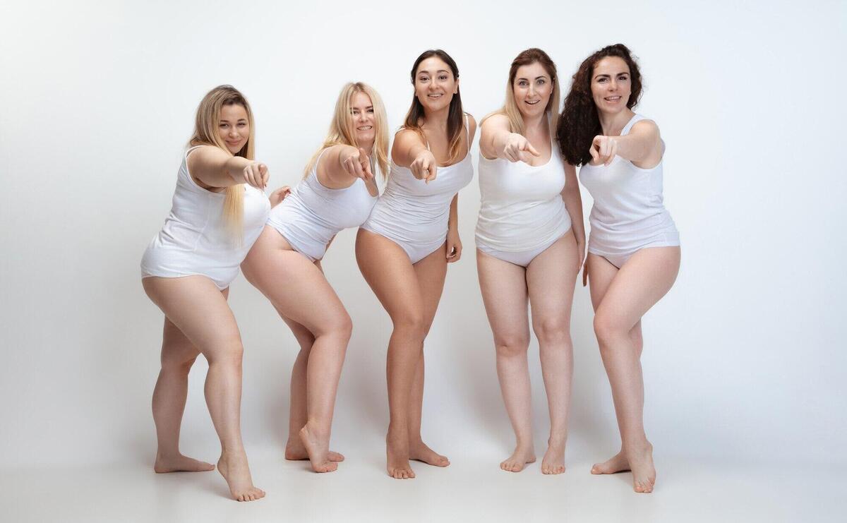 In love with myself. Portrait of beautiful plus size young women posing on white