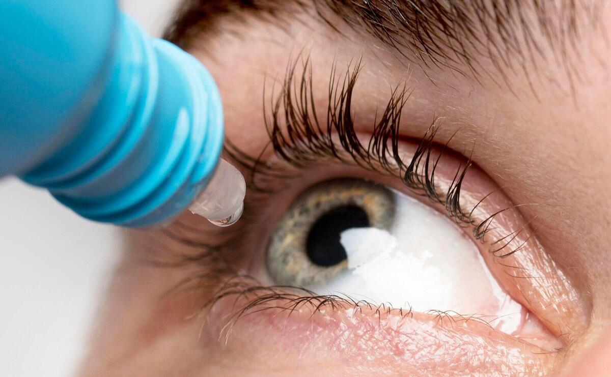 Man using eye drops close-up