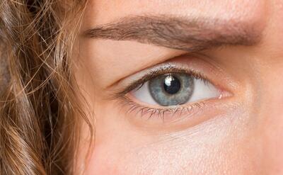 The close up gray eye on face of young beautiful caucasian girl