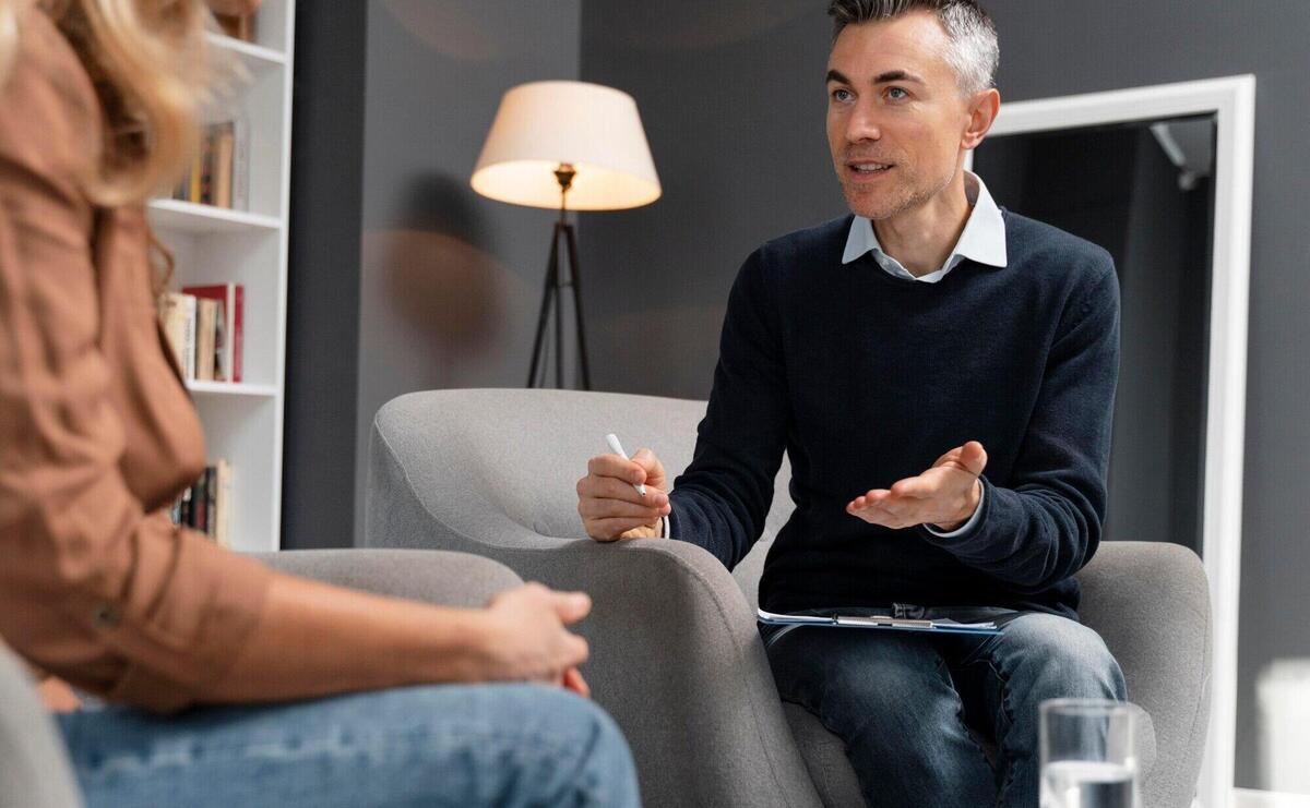 Mid shot patient talking to man therapist