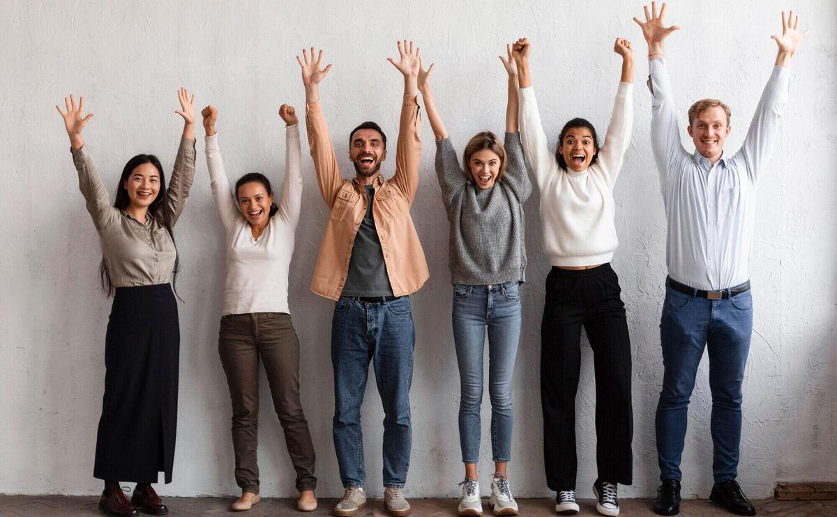 Smiley people putting their hands up at a group therapy session