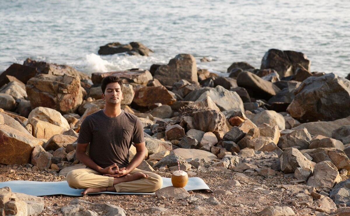 Full shot man doing yoga on mat in nature