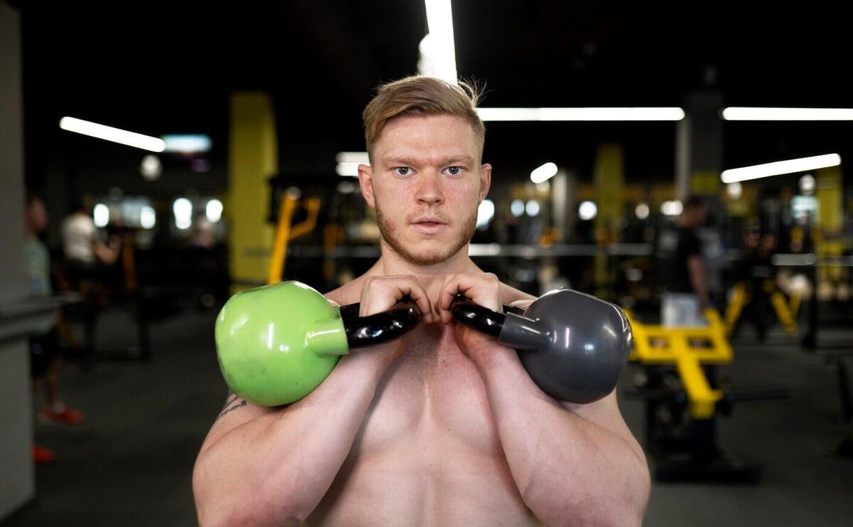 Medium shot man training with kettlebells