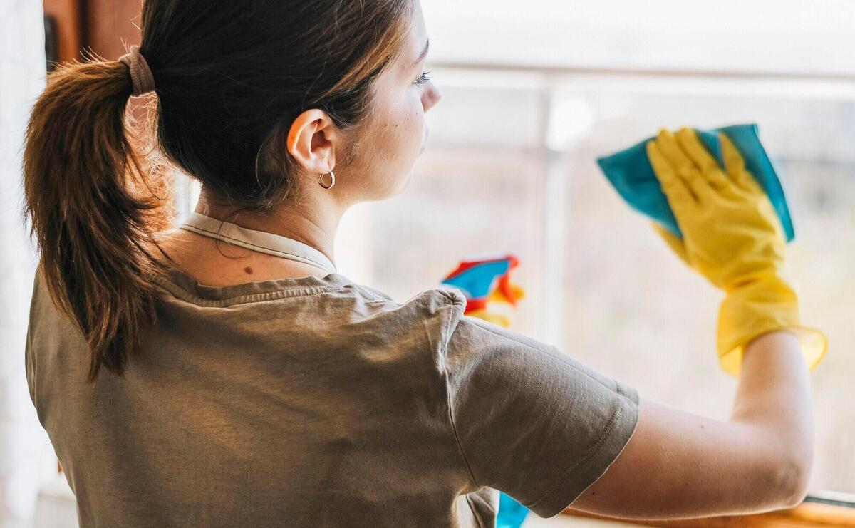 Medium shot woman cleaning window