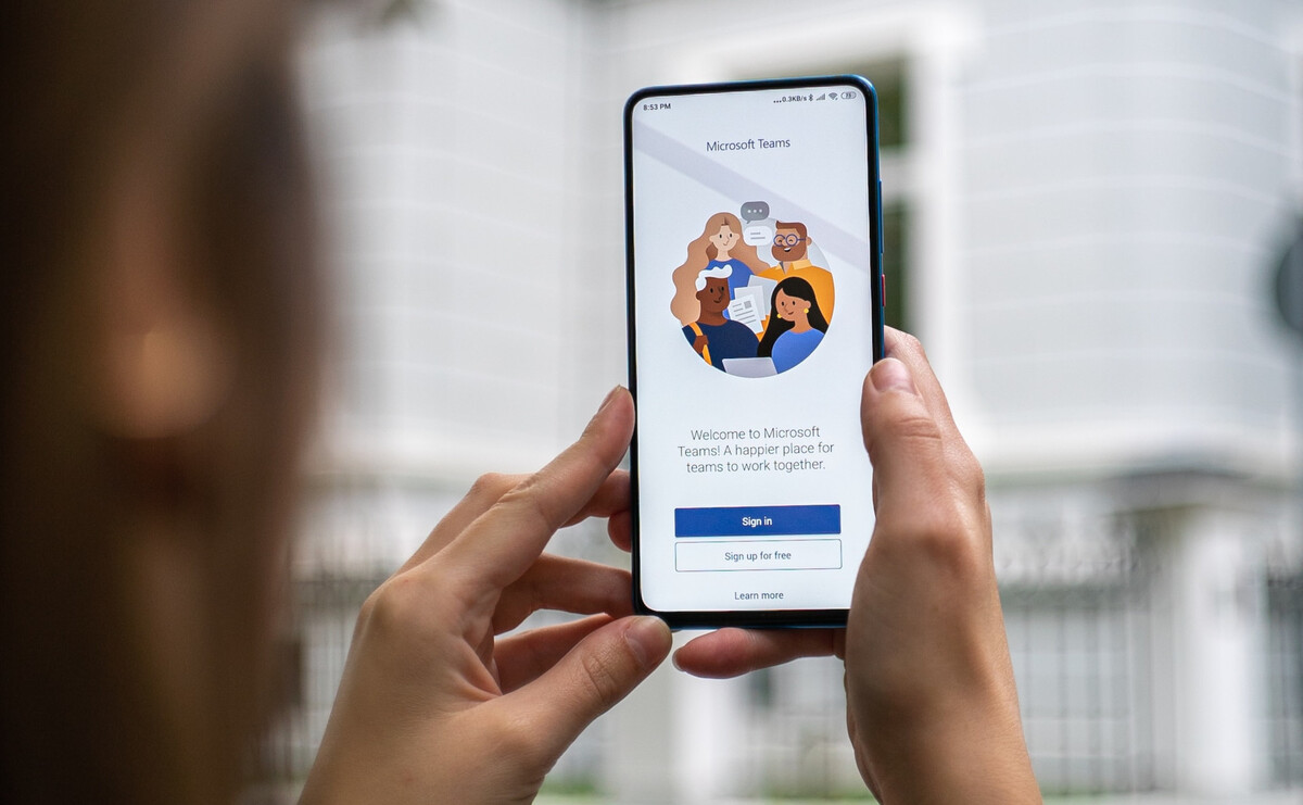 Person holding a phone with Microsoft Teams on the screen.