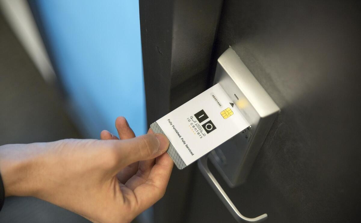A person is using a room entry card.