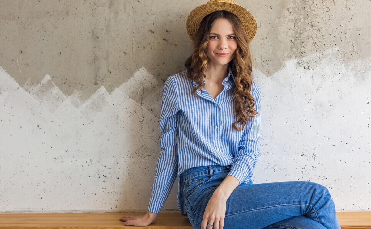 Young attractive stylish woman sitting at wall