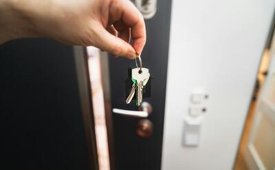 A person is holding a key to a door